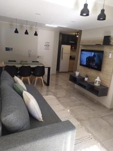 ein Wohnzimmer mit einem grauen Sofa und einem TV in der Unterkunft Departamento 2 dormitorios Nueva Cordoba in Cordoba