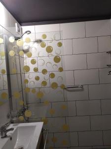 a bathroom with a shower with yellow circles on the wall at Departamento 2 dormitorios Nueva Cordoba in Cordoba