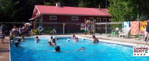 a group of people swimming in a swimming pool at New Glasgow Highlands Campground cabins in New Glasgow