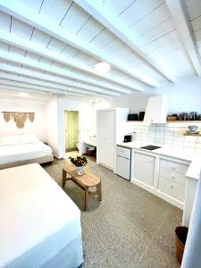 uma cozinha branca com uma cama e uma mesa num quarto em Skepi Town Houses em Míconos
