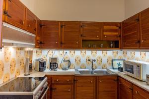 a kitchen with wooden cabinets and a sink and a microwave at Katerina Residence in Zakynthos Town