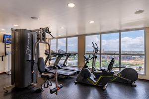 a gym with treadmills and ellipticals in a room with windows at Holiday Inn Manaus by IHG in Manaus