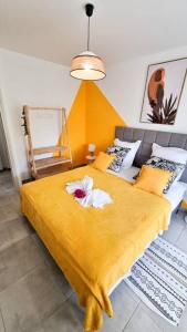 a bedroom with a bed with a yellow blanket at Appartement 2 chambres, avec jardin, grande terrasse, Barbecue, 8 min du centre ville in Fort-de-France