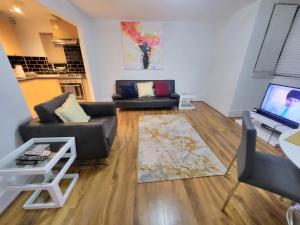 London City Modern Apartment, Woolwich في لندن: غرفة معيشة مع كنبتين وتلفزيون بشاشة مسطحة