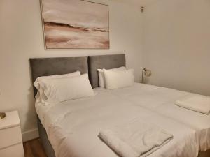duże białe łóżko z 2 poduszkami w obiekcie London City Modern Apartment, Woolwich w Londynie