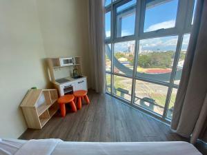 Habitación con cama, 2 sillas de color naranja y ventana grande. en Chariton Hotel Butterworth, en Butterworth
