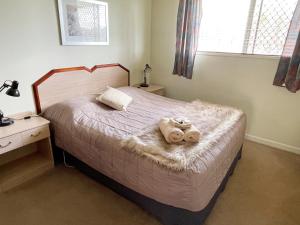 a bedroom with a bed with two towels on it at Clansman Motel in Glen Innes