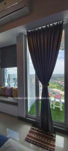 uma janela com uma cortina num quarto com vista em The Paneya Lavanya @Benson Apartment em Surabaya