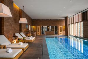 a hotel swimming pool with white lounge chairs and a pool at Humble Boutique Hotel in Taipei