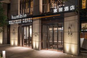Humble Boutique Hotel في تايبيه: مبنى بأبواب دوار في مدينة في الليل