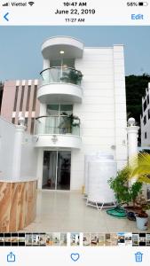 a white building with a balcony in front of it at Homestay coco in Vung Tau