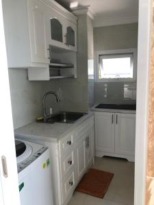 a kitchen with white cabinets and a sink at Homestay coco in Vung Tau