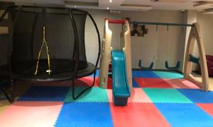 pokój zabaw z trampoliną i huśtawką w obiekcie City Suites w mieście Al-Chubar