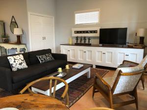 a living room with a couch and a tv at Shorebreak Studio Apartments in Sapphire Beach