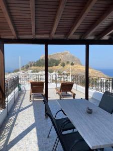 a table and chairs on a patio with a view of the ocean at Jacks Studios in Líndos