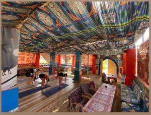a group of people bending over in a room with a colorful ceiling at Nuba Narty in Aswan