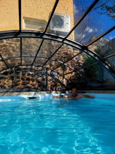 a man laying in a swimming pool in a building at Thermae D'Olimpia & SPA - Adults Only 14 Plus in Băile Herculane