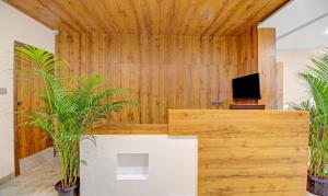 an office with wooden walls and potted plants at Treebo Trend White Inn in Bangalore