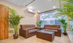 uma sala de estar com dois sofás e vasos de plantas em Treebo Trend White Inn em Bangalore