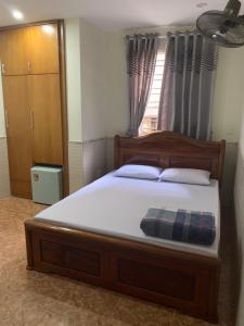 ein großes Bett in einem Schlafzimmer mit Fenster in der Unterkunft Nhà nghỉ Hoàng Anh in Haiphong