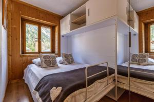 2 letti in una camera con pareti e finestre in legno di Maisonnette Argentée - Happy Rentals a Chamonix-Mont-Blanc