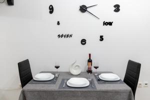 a dining room table with a clock on the wall at K6 Fashion Sparta Apartment in Sparti