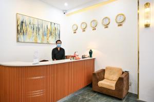 a man in a mask standing at a reception counter at TN Central Hotel in Ho Chi Minh City