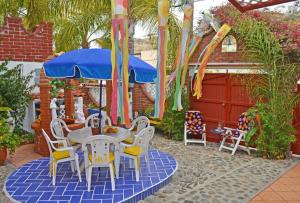 une terrasse avec une table, des chaises et un parasol dans l'établissement Amazingly Romantic Vacation for Your Honeymoon, à Tijuana