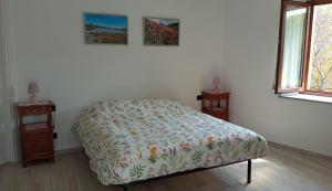 ein Schlafzimmer mit einem Bett und zwei Nachttischen in der Unterkunft Chez Bonjour in Villar Pellice