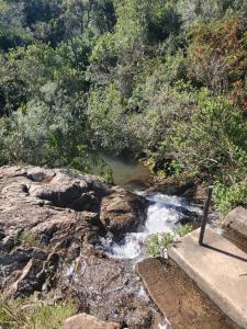 een stroom water met rotsen en bomen op de achtergrond bij casas kiran y kanu in Villa Serrana