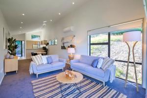 a living room with two blue couches and a table at The Villa Lookout - Queenstown Holiday Villa in Queenstown