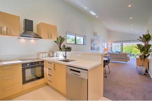a kitchen with a sink and a stove at The Villa Lookout - Queenstown Holiday Villa in Queenstown +10 photos