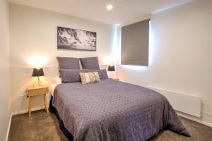 a bedroom with a bed with blue pillows at The Villa Lookout - Queenstown Holiday Villa in Queenstown