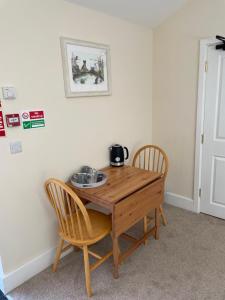 a wooden table and two chairs in a room at The Old Kitchen in Burwarton