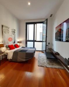 1 dormitorio con 1 cama grande con almohadas rojas en Loft Abad playa Beach Center en Alicante