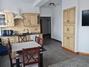 a kitchen with wooden cabinets and a table with chairs at Apartament Centrum 3 Maja in Mikołajki