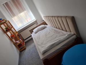 a small bedroom with a bed and a window at Apartament Centrum 3 Maja in Mikołajki