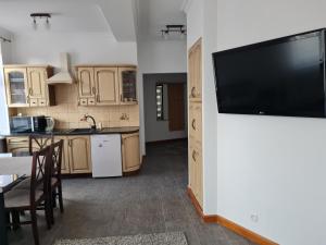 a kitchen with a large flat screen tv on a wall at Apartament Centrum 3 Maja in Mikołajki