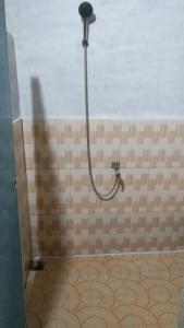 y baño con ducha y pared de azulejos. en Balian Camp penginapan, en Tuk Tuk