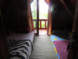 Habitación con 2 camas en una habitación con ventana en Balian Camp penginapan, en Tuk Tuk