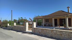 uma casa com uma parede de pedra ao lado de uma rua em *Villa Pap-Live the Greek hospitality in a village* em Néa Sampsoús