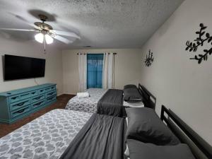 a bedroom with two beds and a flat screen tv at Modern 10 Acre Horse Ranch-Walk to Lake Ray Robert in Pilot Point