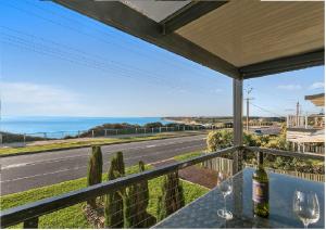a balcony with wine glasses and a view of the ocean at Port Willunga Ocean Views Beachhouse in Port Willunga