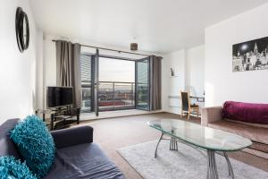 a living room with a couch and a glass table at Liverpool City Centre Apartments - East Village in Liverpool