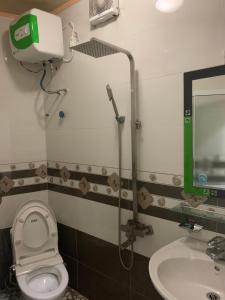 ein Badezimmer mit Dusche, Toilette und Waschbecken in der Unterkunft Nhà nghỉ Hoàng Anh in Haiphong