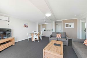 a living room filled with furniture and a fireplace at Port Pacific Resort in Port Macquarie