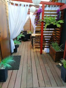 a patio with potted plants and a white curtain at Apartament Antonio 2 Gdańsk in Gdańsk