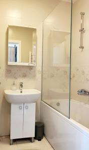 La salle de bains est pourvue d'un lavabo, d'une douche et d'une baignoire. dans l'établissement Cozy nest SAVADA, à Belgrade