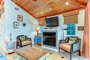 a living room with a fireplace and a tv at Ocean Ave Seaside Cottage in Fernandina Beach