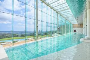 una gran piscina con una gran pared de cristal en Delpino en Sokcho